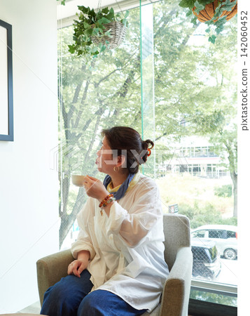 盛夏時節，一位中年女上班族在辦公大樓的休息室休息喝咖啡。 142060452