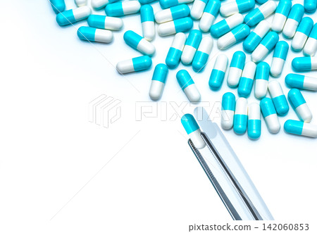Forceps pick white-blue capsule from group of capsule pills. Drugs choose. Antibiotic drug selection. Antibiotic drug resistance concept. QA and QC in pharmaceutical factory concept. Drugs of choice. Forceps pick white-blue capsule from group of capsule pills. Drugs choose. Antibiotic drug selection. Antibiotic drug resistance concept. QA and QC in pharmaceutical factory concept. Drugs of choice. 142060853