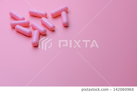 Pink capsule pills on pink background. Woman health insurance budget. Pharmacy store banner. Pharmaceutical industry. Vitamins and supplements. Capsule pills industry. Happy pills. Pills of love. Pink capsule pills on pink background. Woman health insurance budget. Pharmacy store banner. Pharmaceutical industry. Vitamins and supplements. Capsule pills industry. Happy pills. Pills of love. 142060968