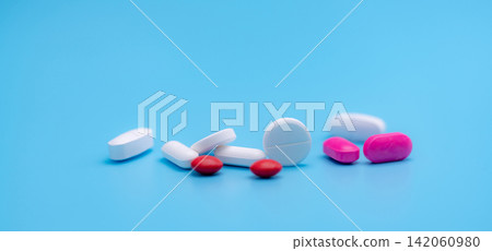 Pharmacy banner. White and pink tablets pills on blue background. Round and oval tablets. Painkiller medicine. Acetaminophen and ibuprofen tablets pills. Pharmaceutical industry. Painkiller tablets. Pharmacy banner. White and pink tablets pills on blue background. Round and oval tablets. Painkiller medicine. Acetaminophen and ibuprofen tablets pills. Pharmaceutical industry. Painkiller tablets. 142060980