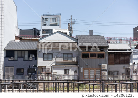 Row of traditional and modern Japanese residential buildings with power lines and copy space in Fukuoka, Japan Row of traditional and modern Japanese residential buildings with power lines and copy space in Fukuoka, Japan 142061223