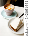 Cup of hot latte coffee on table by the window. 142061441
