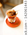 Glass of layered milk latte by the window. 142061443