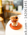 Glass of layered milk latte by the window. 142061445