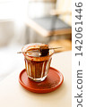 Glass of layered milk latte by the window. 142061446