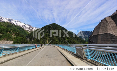 Tourists strolling around Kurobe Dam, part of the Tateyama Kurobe Alpine Route, a popular summer tourist destination. Tourists strolling around Kurobe Dam, part of the Tateyama Kurobe Alpine Route, a popular summer tourist destination. 142061556