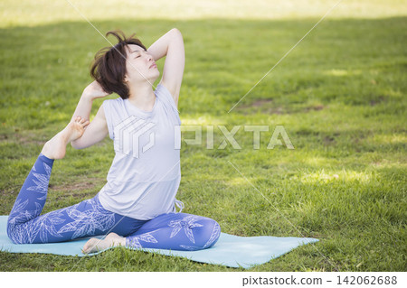 Women doing yoga outdoors 142062688