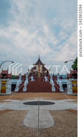 Traditional Thai temple in Rajapruek park with symmetrical pathway and statues in Chiang Mai, Ornate Asian shrine architecture with stairs and cultural landmark in Thailand Traditional Thai temple in Rajapruek park with symmetrical pathway and statues in Chiang Mai, Ornate Asian shrine architecture with stairs and cultural landmark in Thailand 142063394