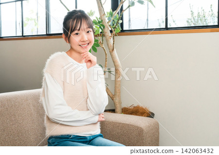 Smiling child, girl sitting on the sofa in her home (thinking, inspiration, idea, imagination) Smiling child, girl sitting on the sofa in her home (thinking, inspiration, idea, imagination) 142063432