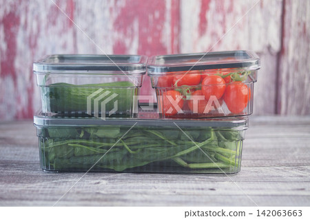 Fresh vegetables in clear containers on a wooden table 142063663