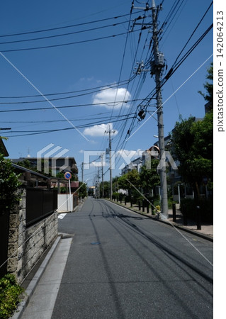 A streetscape of back alleys, a Japanese residential area with power lines and buildings. A streetscape of back alleys, a Japanese residential area with power lines and buildings. 142064213
