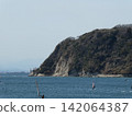 The ocean where people are windsurfing. 142064387