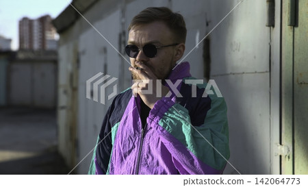 Tranquil Individual In Bright Sunlight. Relaxed Person With Sunglasses And Cigarette Under Midday Sun. Media Tranquil Individual In Bright Sunlight. Relaxed Person With Sunglasses And Cigarette Under Midday Sun. Media 142064773