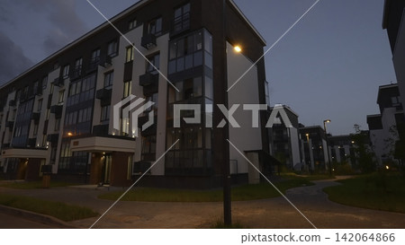 Modern apartment complex at dusk with streetlights Modern apartment complex at dusk with streetlights 142064866