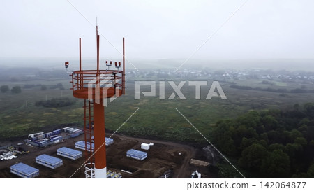 Red telecommunications tower above rural landscape Red telecommunications tower above rural landscape 142064877