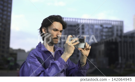 Man using smartphone outdoors in a modern city setting Man using smartphone outdoors in a modern city setting 142064945