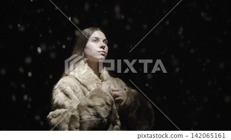 Young woman in fur coat under falling snow Young woman in fur coat under falling snow 142065161