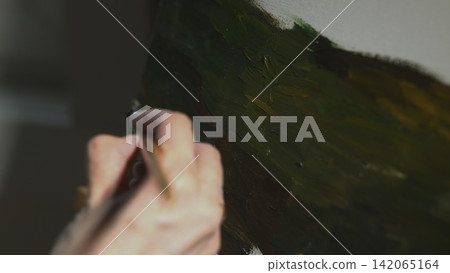 Hand painting a textured green surface in close-up Hand painting a textured green surface in close-up 142065164
