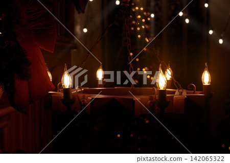 Cozy Christmas chandelier with flickering candle lights and festive bokeh background 142065322