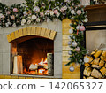 Warmth of Holiday Spirit: A Cozy Fireplace Adorned with Elegant Decorations and Festive Ornaments Creating a Winter Wonderland Ambiance 142065327