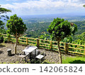 chairs and tables in an open space on a hill. 142065824