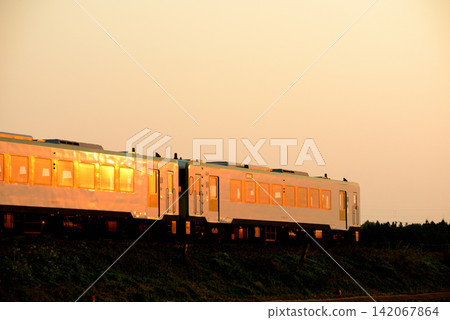 A local train running on the Ban'etsu West Line, bathed in the setting sun. A local train running on the Ban'etsu West Line, bathed in the setting sun. 142067864
