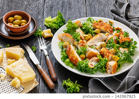 Crispy breaded pork schnitzel salad on a plate Crispy breaded pork schnitzel salad on a plate 142067925