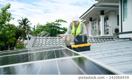 Asian Engineer Inspecting Solar Panels on Residential Rooftop with Laptop and Toolbox Asian Engineer Inspecting Solar Panels on Residential Rooftop with Laptop and Toolbox 142068439