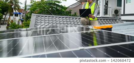 Solar Panel Technician Inspecting Rooftop Installation with Laptop and Toolbox in Residential Area Solar Panel Technician Inspecting Rooftop Installation with Laptop and Toolbox in Residential Area 142068472