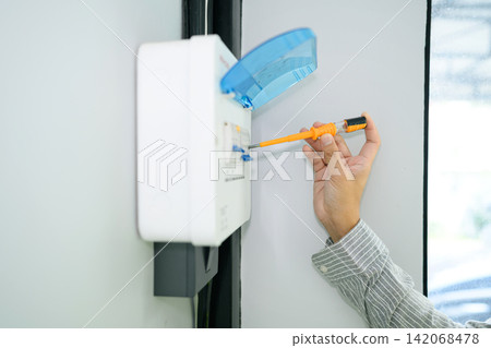 Closeup Electrician Inspecting Electrical Circuit Breaker Panel on Wall During Home Maintenance Service Closeup Electrician Inspecting Electrical Circuit Breaker Panel on Wall During Home Maintenance Service 142068478