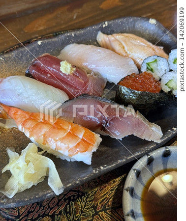 陶瓷盤盛裝的握壽司：蝦捲、鮭魚籽捲和黃瓜捲等各種口味。 142069199