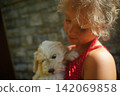 Child Holding Puppy with Loving Expression Outdoors 142069858