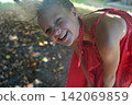 Joyful Child in Red Dress Enjoying a Sunny Day 142069859