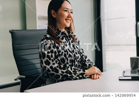 Confident asian business woman standing in modern office Confident asian business woman standing in modern office 142069954