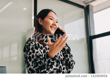 Confident asian business woman standing in modern office Confident asian business woman standing in modern office 142069956
