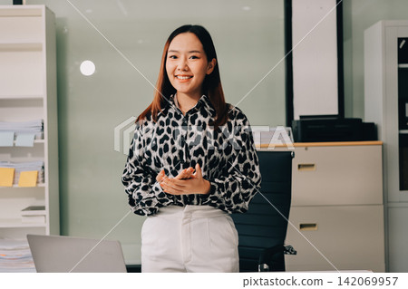 Confident asian business woman standing in modern office Confident asian business woman standing in modern office 142069957