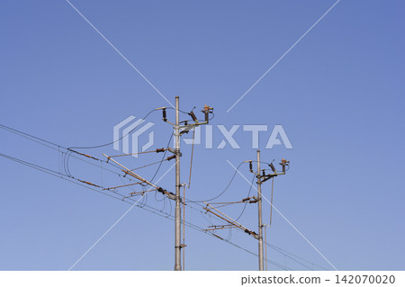 Railway overhead line poles against clear blue sky Railway overhead line poles against clear blue sky 142070020