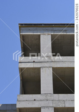 Concrete building corner under construction against blue sky Concrete building corner under construction against blue sky 142070028