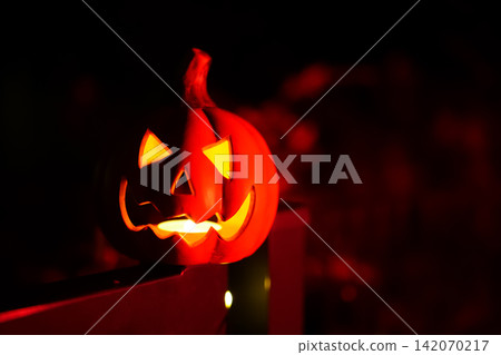 Halloween lantern glowing in dark outdoor setting with decorative lights. Halloween lantern glowing in dark outdoor setting with decorative lights. 142070217