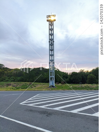 Highway rest area and lighting towers at dusk Highway rest area and lighting towers at dusk 142070339