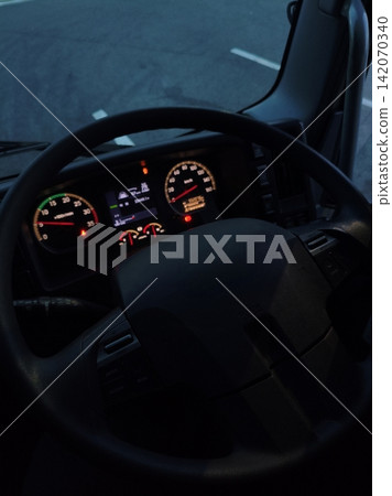 The instrument panel area of the driver's seat of a large truck driving at night. The instrument panel area of the driver's seat of a large truck driving at night. 142070340