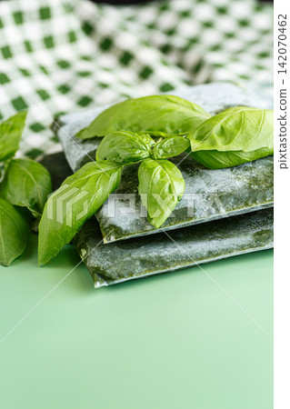 Basil preserved by freezing in vacuum bags with green leaves Basil preserved by freezing in vacuum bags with green leaves 142070462