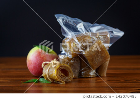 Dried apple pastila in vacuum bag on dark wooden background Dried apple pastila in vacuum bag on dark wooden background 142070483