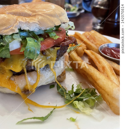 A classic combination of a juicy burger with fresh toppings served alongside golden, crispy French fries. Perfect for a satisfying meal that blends savory flavors and crunchy textures. A classic combination of a juicy burger with fresh toppings served alongside golden, crispy French fries. Perfect for a satisfying meal that blends savory flavors and crunchy textures. 142070814