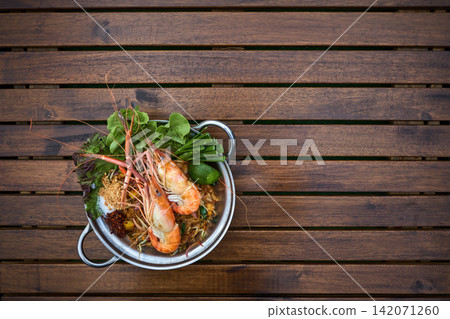 photo of pad thai with two fresh water shrimps on the wooden table with copy space photo of pad thai with two fresh water shrimps on the wooden table with copy space 142071260