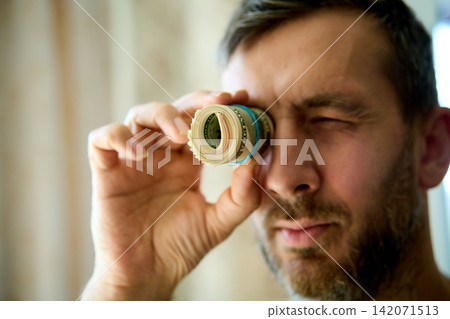 Man looking through dollar bill roll 142071513