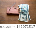 Hundred dollar bills caught in wooden mousetrap 142071517