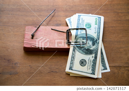 Hundred dollar bills caught in wooden mousetrap Hundred dollar bills caught in wooden mousetrap 142071517