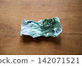 Crumpled hundred euro bill on wood background 142071521