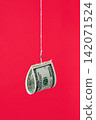 One hundred dollar bill on fishing hook over red background 142071524